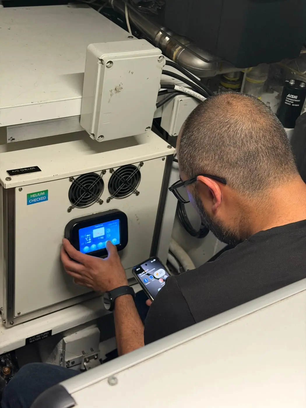 HOSS Marine technician configuring a control panel aboard a yacht