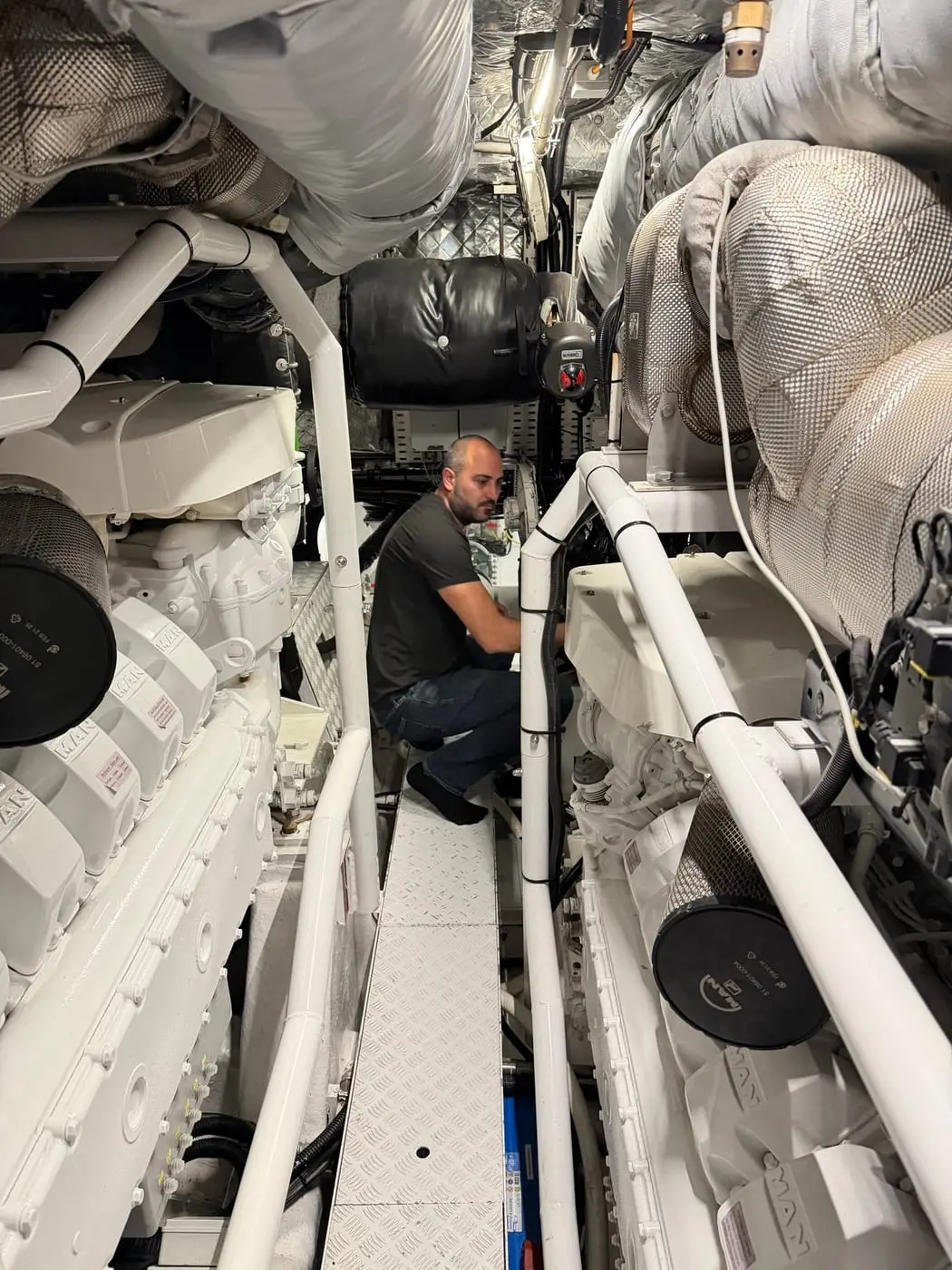 HOSS Marine technician servicing equipment in a yacht engine room